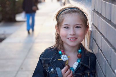 Portrait of girl by brick wall