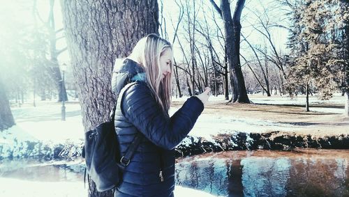 Woman sitting on tree trunk