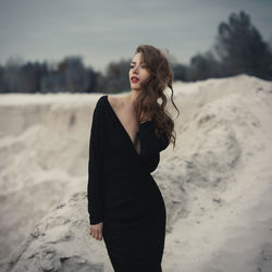 Beautiful mid adult woman standing on sand at beach