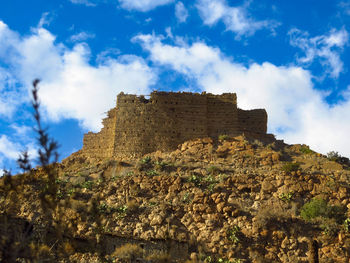 Low angle view of historic building against cloudy sky