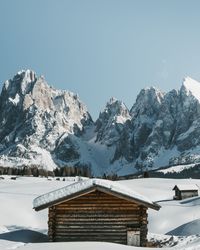 Log cabin against snowcapped mountains