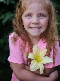 Portrait of cute girl holding pink flower