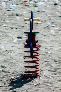 Close-up of spring ride amidst sand