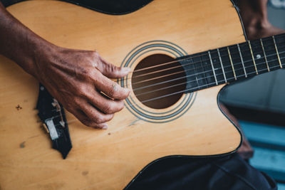 Midsection of man playing guitar