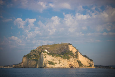 Rock formations by sea against sky