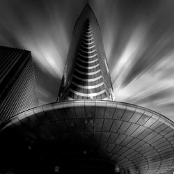 Low angle view of skyscraper against cloudy sky