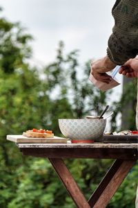 Man holding ice cream in bowl on table