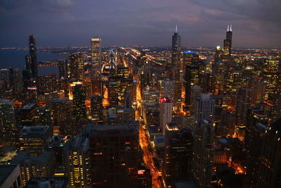 Illuminated cityscape against sky at night