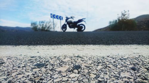 Close-up of bicycle by water against sky