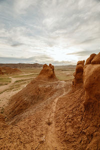 Path winds through a moody desert in goblin valley state park utah
