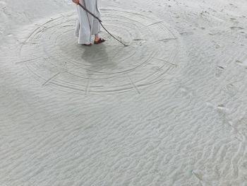 Low section of person walking on beach