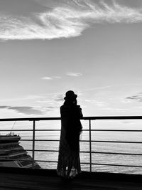 Silhouette woman looking at sea against sky