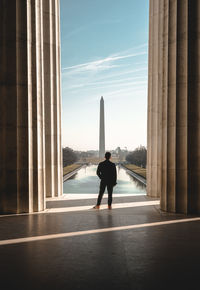 Rear view of man standing by pillar