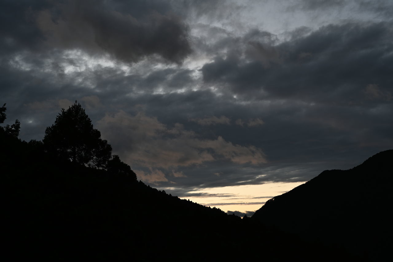 cloud - sky, sky, beauty in nature, silhouette, tranquility, scenics - nature, tranquil scene, sunset, nature, tree, no people, low angle view, mountain, idyllic, dramatic sky, storm, overcast, non-urban scene, outdoors, dark, ominous