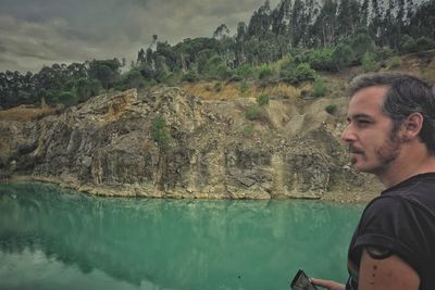 Portrait of man on rock by water