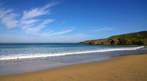 Scenic view of beach against blue sky