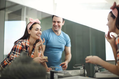 Portrait of smiling friends talking on table