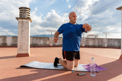 Middle-aged caucasian man doing exercises and sports on the terrace.