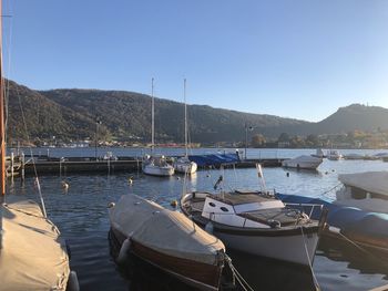 Sailboats moored on sea against clear sky