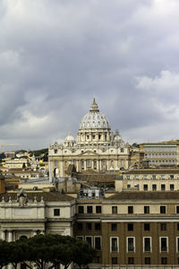 Buildings in city against cloudy sky