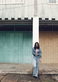 Portrait of woman standing against wall