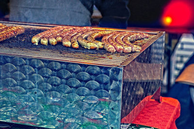 Close-up of man preparing food on barbecue grill