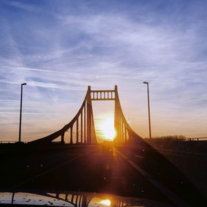 Bridge over road against sky during sunset