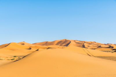 Scenic view of desert against clear blue sky