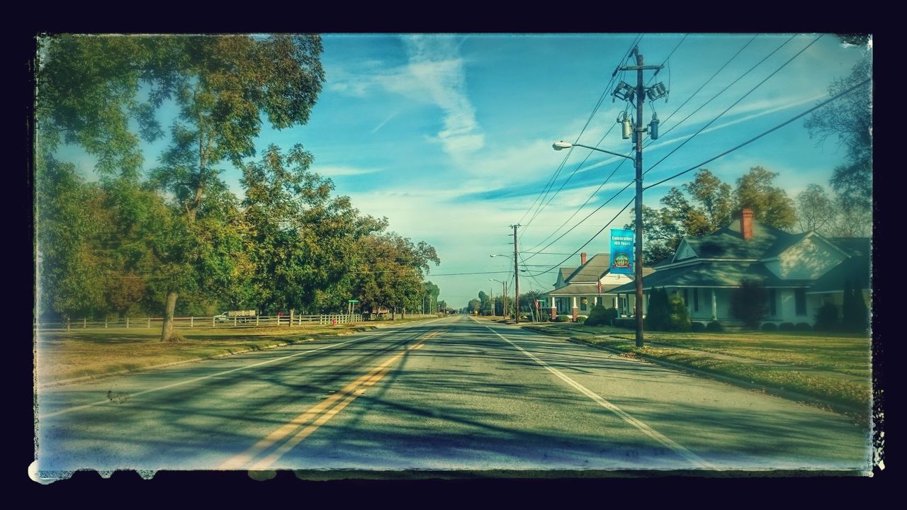 transfer print, transportation, tree, road, sky, auto post production filter, the way forward, building exterior, street, diminishing perspective, built structure, car, architecture, power line, electricity pylon, vanishing point, empty, road marking, day, house