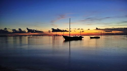 Silhouette sailboats in sea against sky during sunset