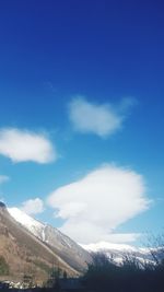 Scenic view of snow mountains against blue sky