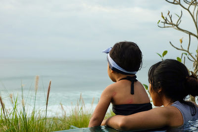 Rear view of people looking at sea against sky