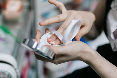 Close-up of woman holding compact powder