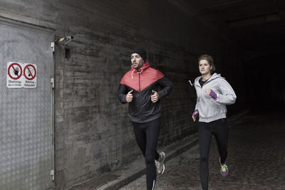 Sporty couple running in tunnel