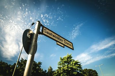 Low angle view of road sign against blue sky