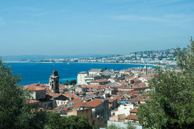 High angle view of townscape by sea against sky