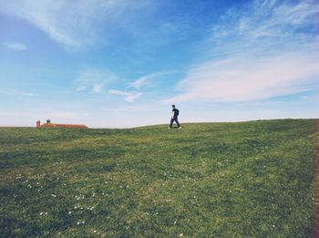 People on grassy field against sky
