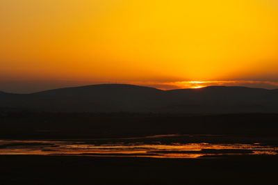 Scenic view of silhouette mountain against romantic sky at sunset