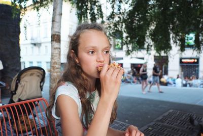 Girl eating while sitting outdoors