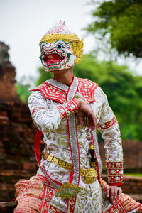 Person in costume dancing against trees