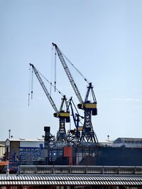 Low angle view of crane against clear sky