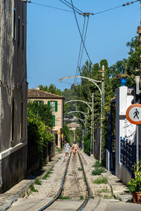 Railroad tracks amidst buildings against sky