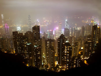 Illuminated cityscape against sky at night