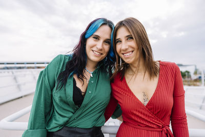 Cheerful sisters standing together at bridge