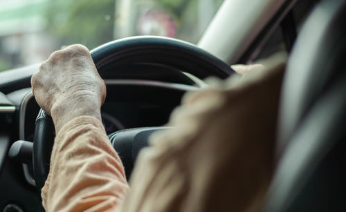 Cropped hand of man driving car