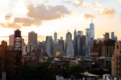 View of financial district manhattan skyline and brooklyn buildings at sunset