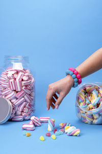 Female hand using chopsticks with candy sushi