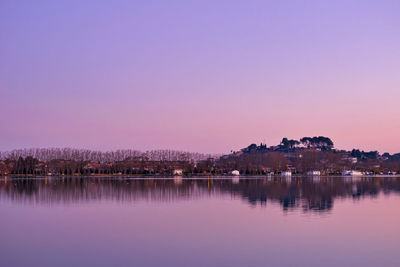 Scenic view of lake against clear sky at sunset