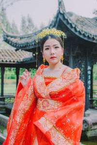 Young woman in traditional clothing standing at temple