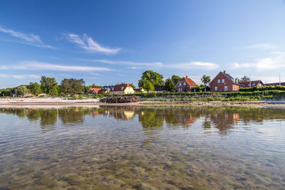 Scenic view of lake by building against sky